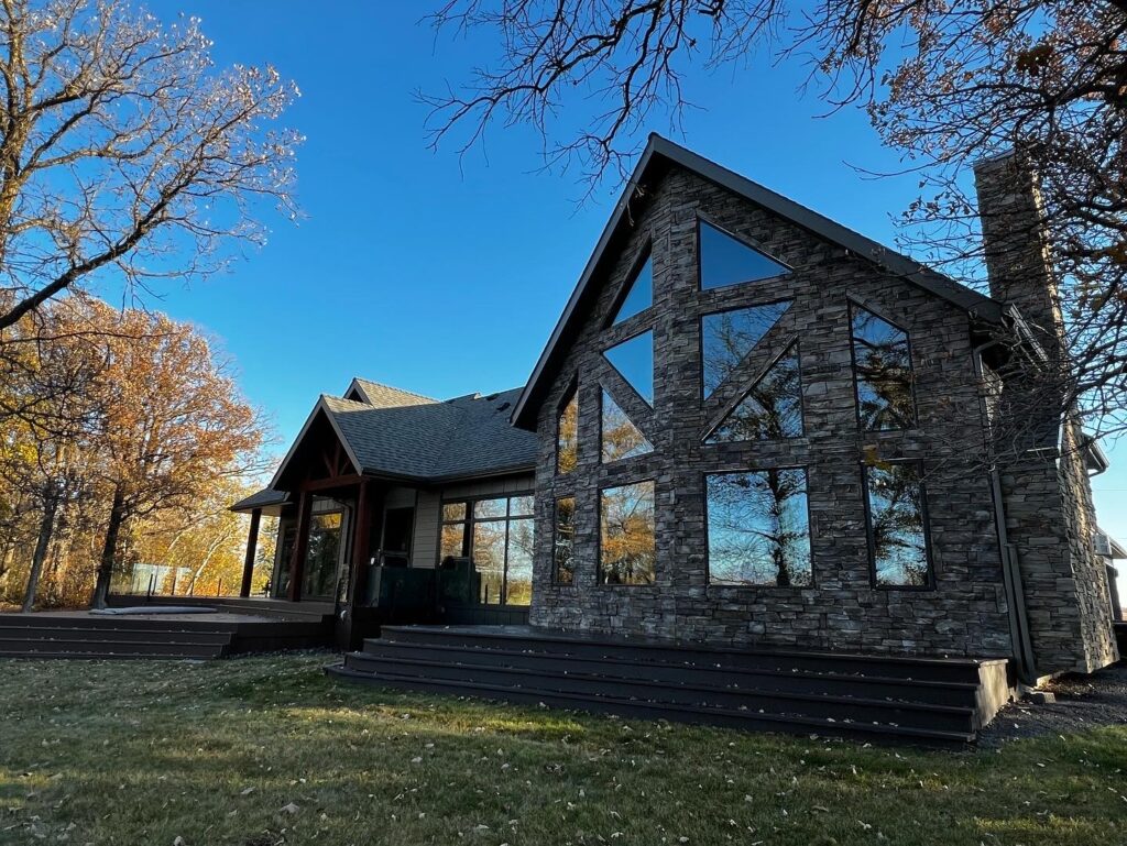 Exterior view of Ron’s Window Cleaning’s modern, stone-clad house surrounded by a well-maintained lawn